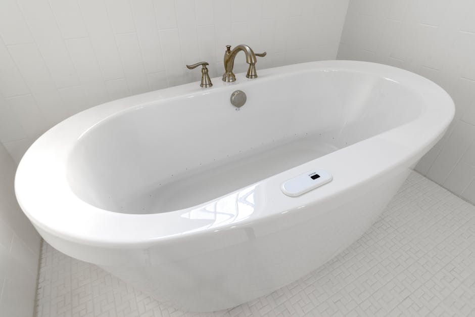 A clean and empty white porcelain bathtub in a minimalist, luxury bathroom.